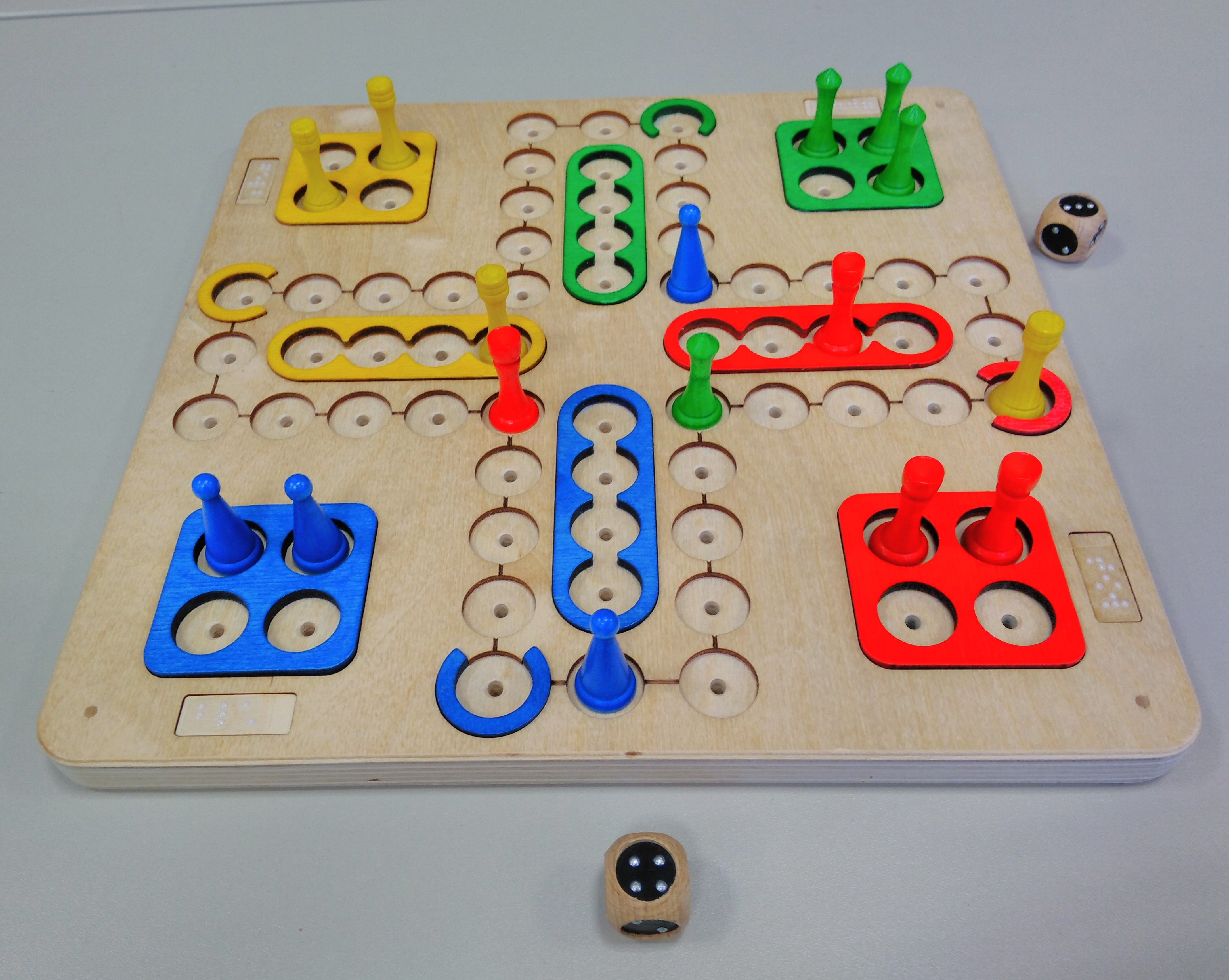 Spiel mit farbigen, markierten Feldern, farbige Spielfiguren zum Stecken und unterschiedlichen Kopfformen, taktiler Würfel