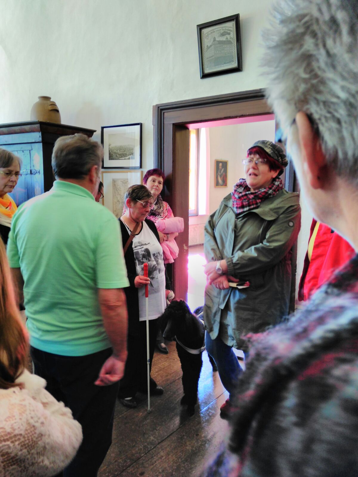 Besuch der Burg Posterstein Die Burgführerin steht vor einer offenen Tür und erzählt den Besuchern etwas zur Geschichte der Burg Posterstein