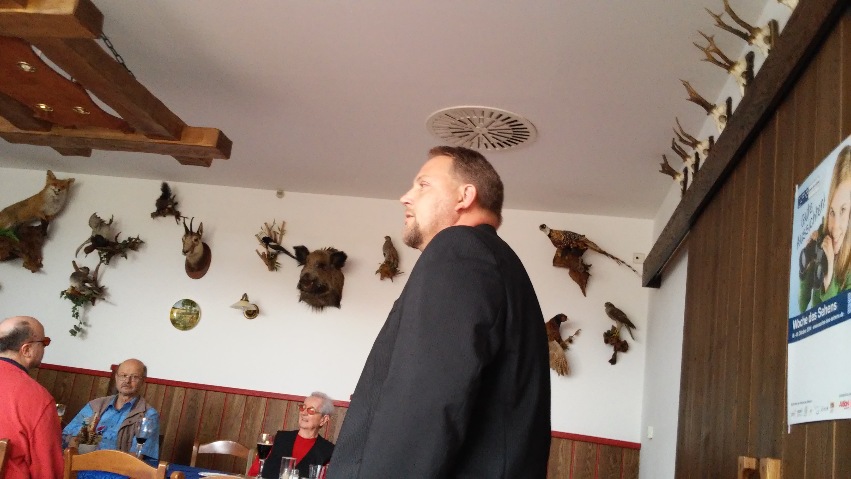 Herr Münzner spricht zum Thema Blindenführhund Ein Mann steht in einem Raum und spricht