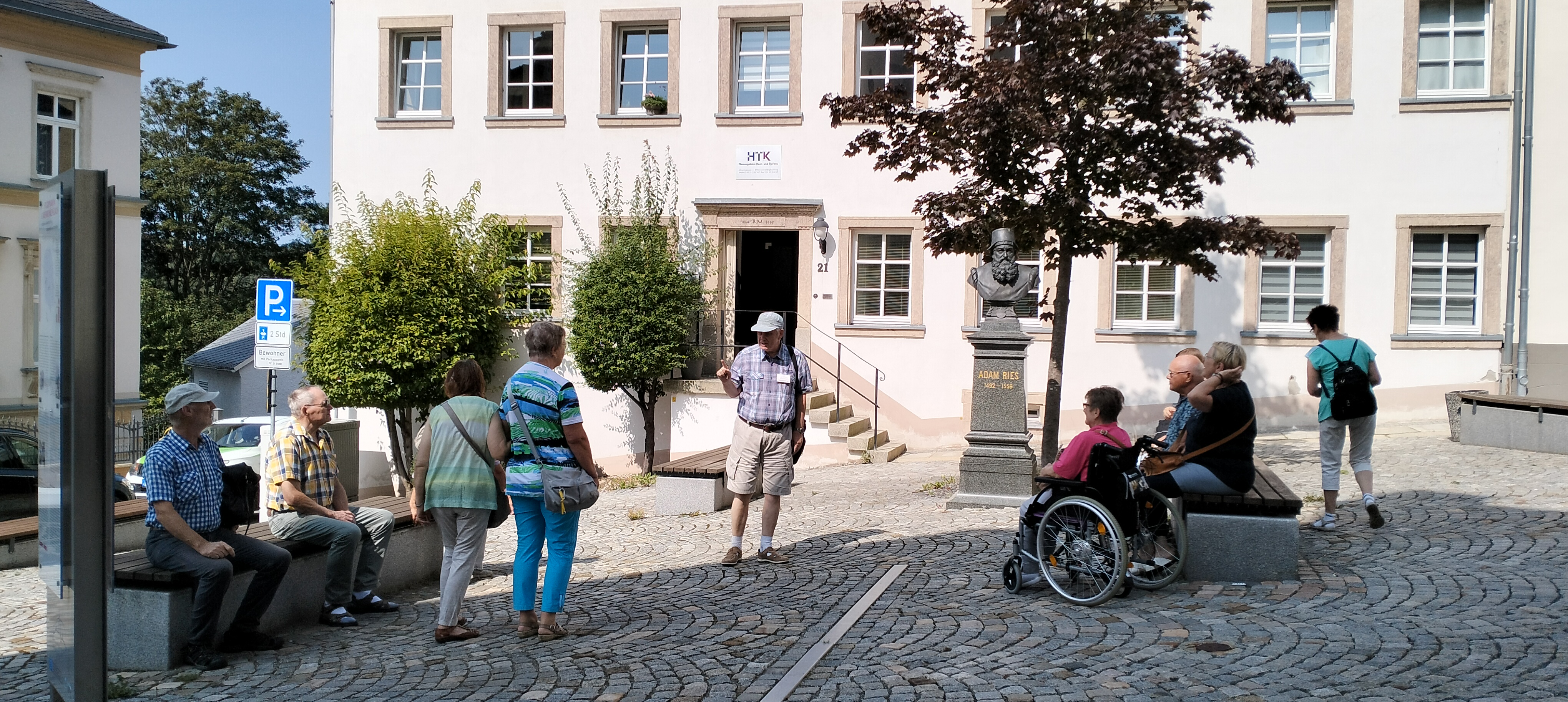 Die Teilnehmer des Stadtrundgangs lauschen den Ausführungen zu Adam Rieß. 
