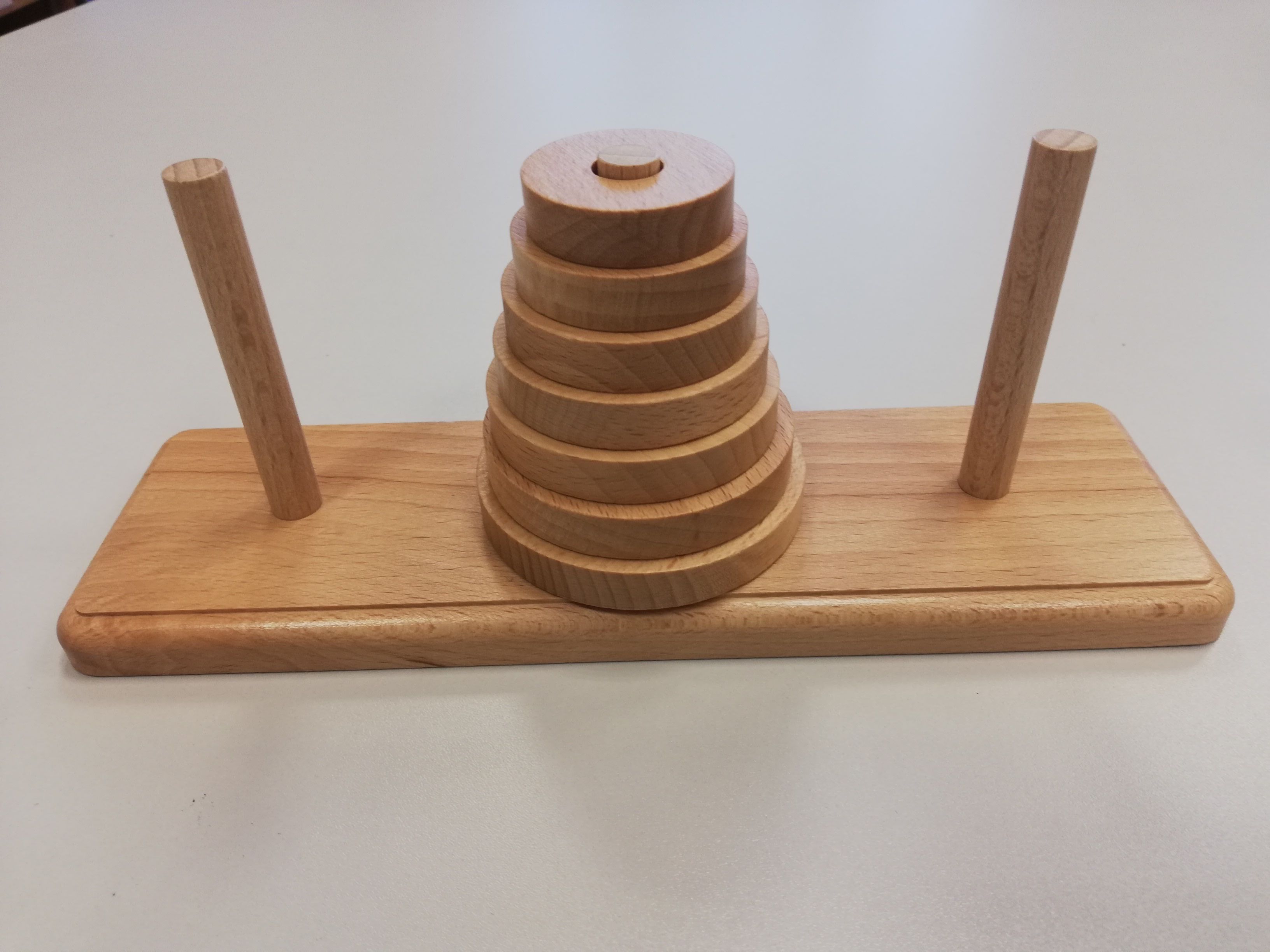 Das Spiel besteht aus drei gleich großen Stäben A, B und C, auf A liegen mehrere gelochte Scheiben in verschiedenen Größen. Die größte oben und die kleinste unten.